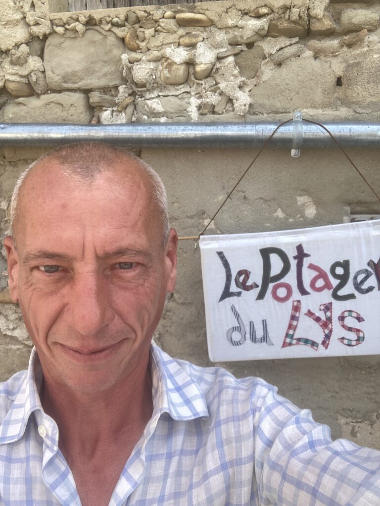 Thierry devant la bannière du Potager du Lys